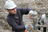 Close up of man inspecting natural gas pipes