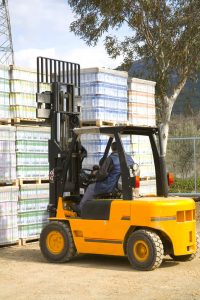 Fork lift operator near pile of pallets